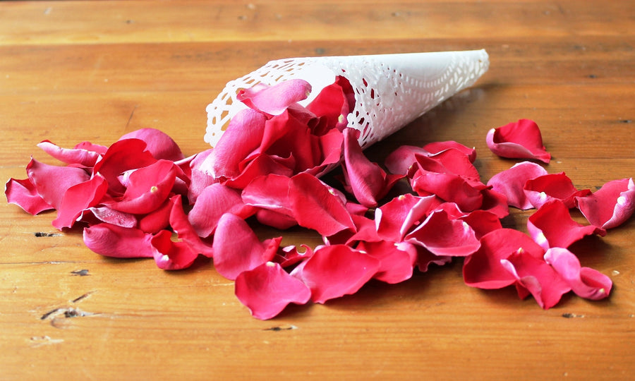 Red rose petals on a table, cones not included.